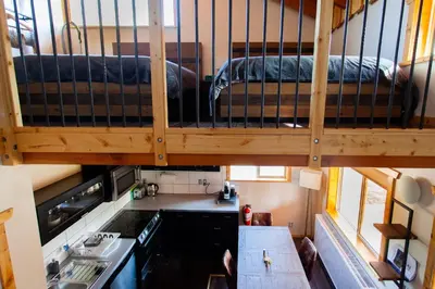 a small kitchen with a bunk bed in a tiny house at Red Cariboo Apartments in Anahim Lake