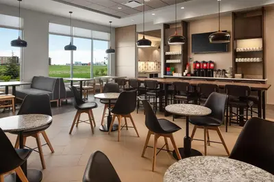 a restaurant with tables and chairs and a bar at Hyatt Place Calgary Airport in Calgary