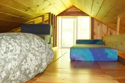 a room with a bed and a couch and a window at The Magical Dome in Lund