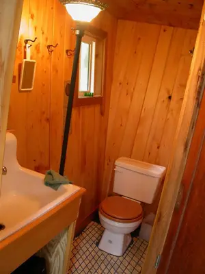 a wooden bathroom with a toilet and a sink at The Magical Dome in Lund