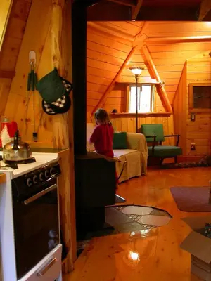 a woman sitting in a kitchen in a cabin at The Magical Dome in Lund