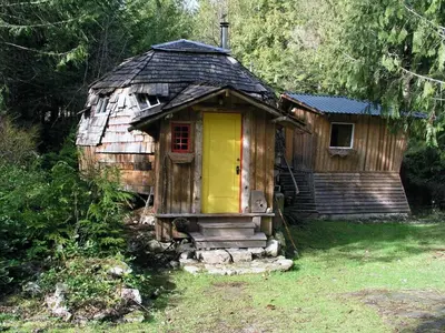 a small wooden house with a yellow door at The Magical Dome in Lund