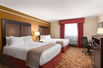 a hotel room with two beds and a television at Travelodge by Wyndham Meadow Lake in Meadow Lake