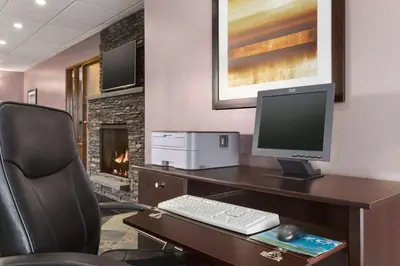 a desk with a computer monitor and a keyboard at Travelodge by Wyndham Meadow Lake in Meadow Lake