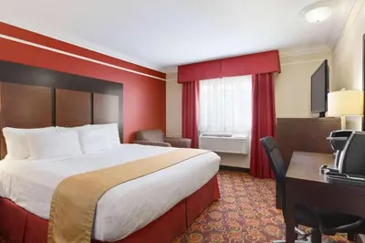 a hotel room with a bed and a desk at Travelodge by Wyndham Meadow Lake in Meadow Lake