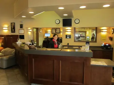 a woman sitting at a counter in a room at Super 8 by Wyndham Fort St. John BC in Fort Saint John
