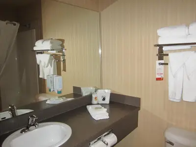 a bathroom with a sink and a mirror at Super 8 by Wyndham Fort St. John BC in Fort Saint John