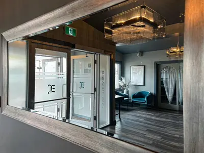 a large mirror in a room with a table at Edgewater Hotel in Whitehorse