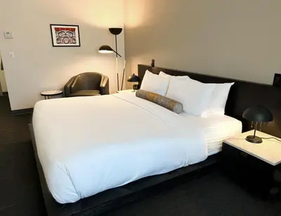 a large white bed in a hotel room at Edgewater Hotel in Whitehorse