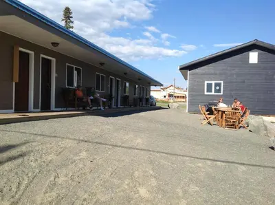 a group of people sitting at a table outside of a building at Parkside Inn in Haines Junction