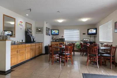 a dining room with tables and chairs and a restaurant at Super 8 by Wyndham Williams Lake BC in Williams Lake