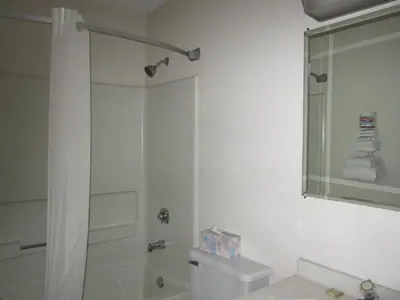 a bathroom with a shower and a toilet and a sink at Super 8 by Wyndham Williams Lake BC in Williams Lake