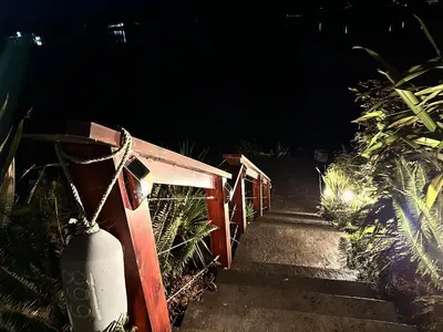 a set of stairs leading up to a gate at night at Waterfront Hot Tub Firepit King Bed - 6H in Ucluelet