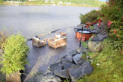 a fire pit next to a body of water at Waterfront Hot Tub Firepit King Bed - 6H in Ucluelet