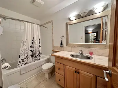 a bathroom with a sink and a toilet and a mirror at Cozy 2 Bedroom Waterfront Cottage With Hot Tub! in Ucluelet