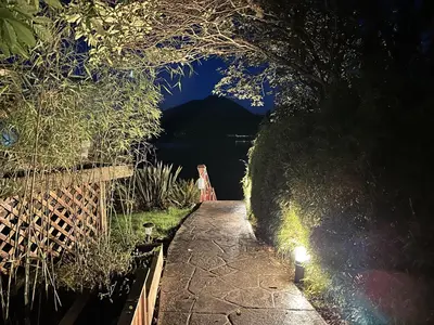 a walkway with a view of a lake at night at Oceanfront Room With Hot Tub & Firepit in Ucluelet