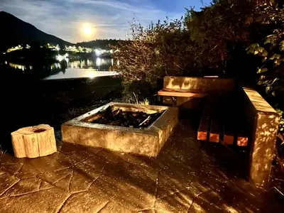 a bench and a fire pit next to a table at Oceanfront Room With Hot Tub & Firepit in Ucluelet