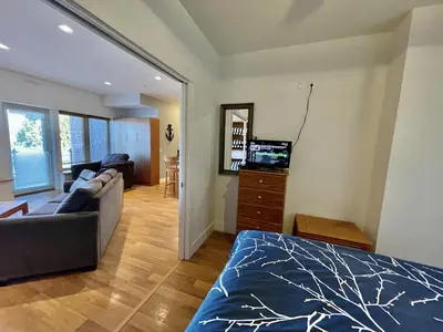 a living room with a bed and a couch and a television at Marina View On The Harbour in Ucluelet