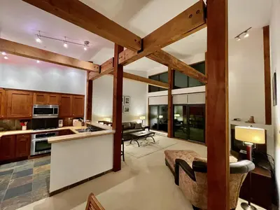 a kitchen with wooden beams and a living room at Top-Floor Villa With Pacific Ocean Views Bbv in Ucluelet