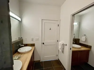 a bathroom with two sinks and a mirror at Top-Floor Villa With Pacific Ocean Views Bbv in Ucluelet