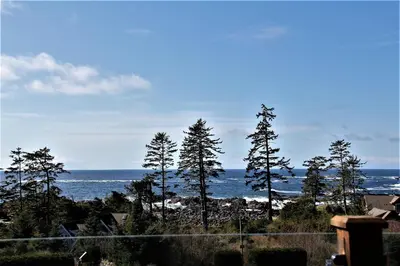 a view of the ocean from a house with trees at Top-Floor Villa With Pacific Ocean Views Bbv in Ucluelet