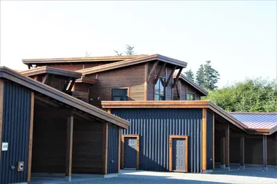 a house with a gambrel roof and a garage at Top-Floor Villa With Pacific Ocean Views Bbv in Ucluelet