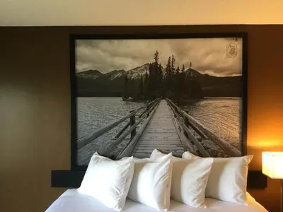 a painting of a pier over a bed with pillows at Super 8 by Wyndham Spruce Grove in Spruce Grove