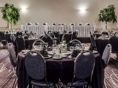 a group of tables and chairs in a room at Heritage Inn Hotel & Convention Centre - High River in High River