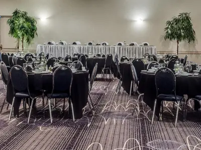 a room full of tables and chairs with tablesearcher at Heritage Inn Hotel & Convention Centre - High River in High River
