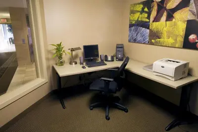 a desk with a laptop computer and a printer at Heritage Inn & Suites - Brooks in Brooks