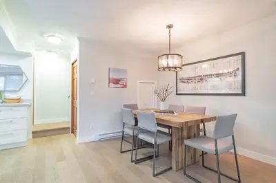 a kitchen and dining room with a wooden table and chairs at Sunpath by Outpost Whistler in Whistler