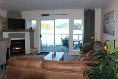 a living room with leather couches and a fireplace at Siennas Harbour House in Tofino