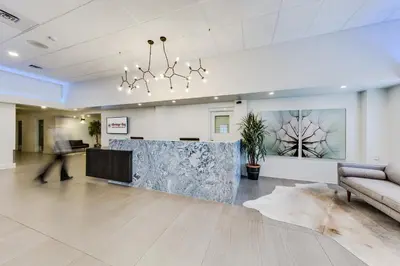 an office lobby with a couch and a reception desk at Heritage Inn Hotel & Convention Centre - Brooks in Brooks