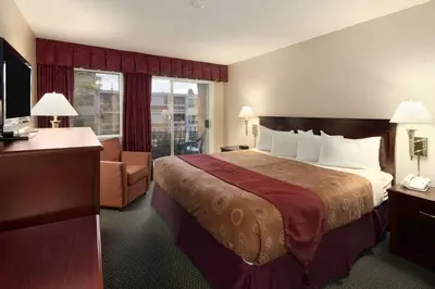 a hotel room with a bed and a chair at Travelodge by Wyndham Nanaimo in Nanaimo