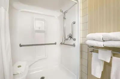 a bathroom with a shower with white towels at Super 8 by Wyndham High Level AB in High Level