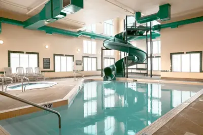 a swimming pool with a slide in a building at Super 8 by Wyndham High Level AB in High Level