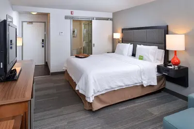 a hotel room with a bed and a flat screen tv at Hampton Inn & Suites by Hilton Calgary University NW in Calgary