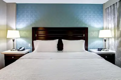 a bedroom with a large bed with two lamps at Hampton Inn & Suites by Hilton Calgary-Airport in Calgary