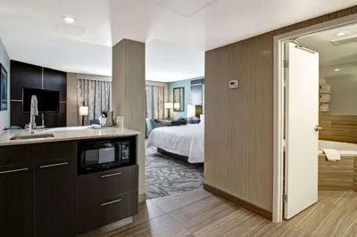 a hotel room with a bed and a bathroom at Hampton Inn & Suites by Hilton Calgary-Airport in Calgary
