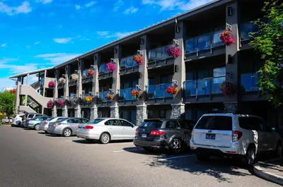 a parking lot with cars parked in front of a building at Accent Inns Burnaby in Burnaby