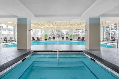 a swimming pool with blue water in a building at Hilton Garden Inn Calgary Airport in Calgary
