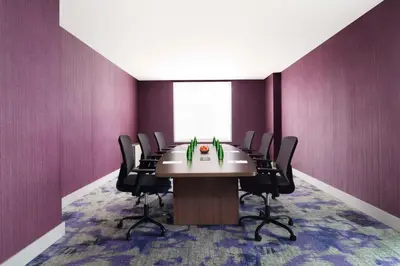 a conference room with a table and black chairs at Hilton Garden Inn Calgary Airport in Calgary