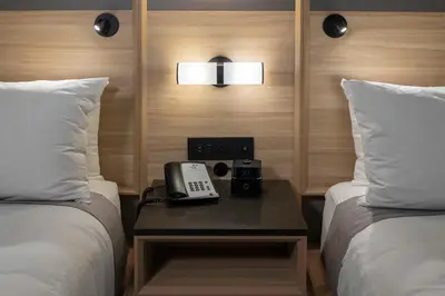 a hotel room with two beds and a phone on a table at Accent Inns Kelowna in Kelowna