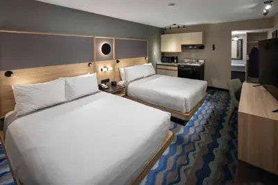 a hotel room with two beds and a kitchen at Accent Inns Kelowna in Kelowna
