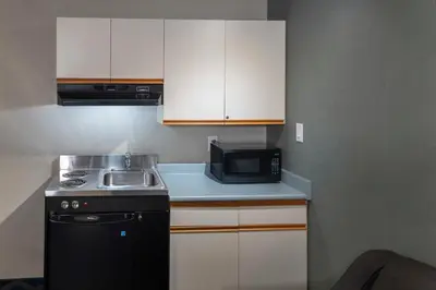 a small kitchen with a sink and a microwave at Accent Inns Kelowna in Kelowna