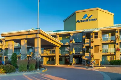 a large yellow building with a sign on it at Accent Inns Kamloops in Kamloops