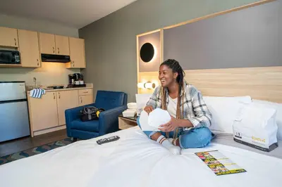 a woman sitting on top of a bed at Accent Inns Kamloops in Kamloops