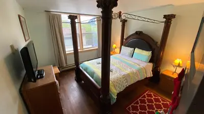 a bedroom with a canopy bed and a window at Historic Hotel Bayview in Stewart