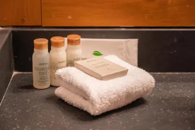 a counter with three bottles of soap and a pile of towels at Glaciers Lodge by Outpost Whistler in Whistler