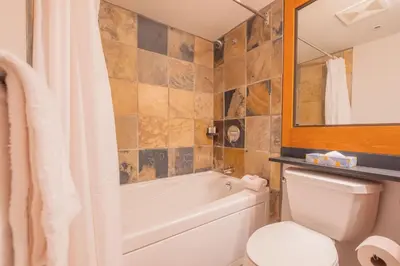a bathroom with a tub and a toilet and a sink at Glaciers Lodge by Outpost Whistler in Whistler